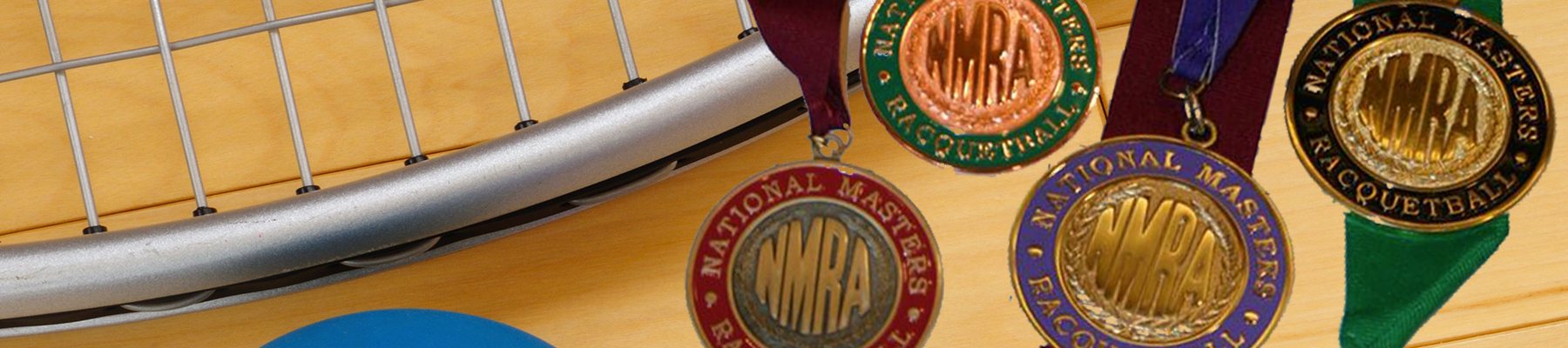 NMRA championship medals in bronze, silver and gold on their ribbons, resting beside a racquet and a blue ball on a hardwood court